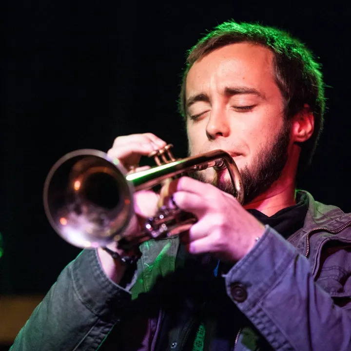 Hugh Parsons performing on trumpet under stage lights